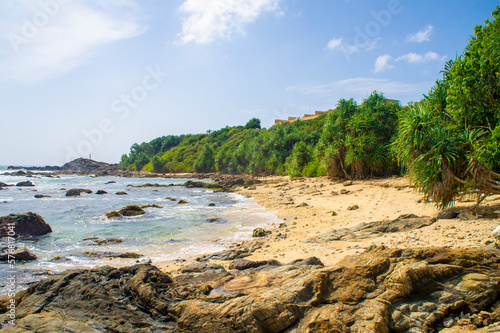 Beautiful tropical landscape. A stone ocean shore with waves and rocks. Beautiful texture background for tourism, design and advertising