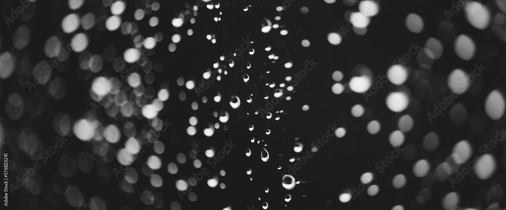 Obraz premium Atmospheric minimal grayscale backdrop with rain droplets on glass. Wet window with rainy drops and dirt spots closeup. Blurry minimalist monochrome background of dirty window glass with raindrops.