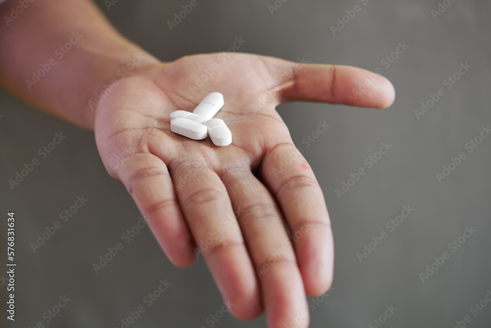 Close up of man hand holding pills with copy space Close up of man hand holding pills with copy space