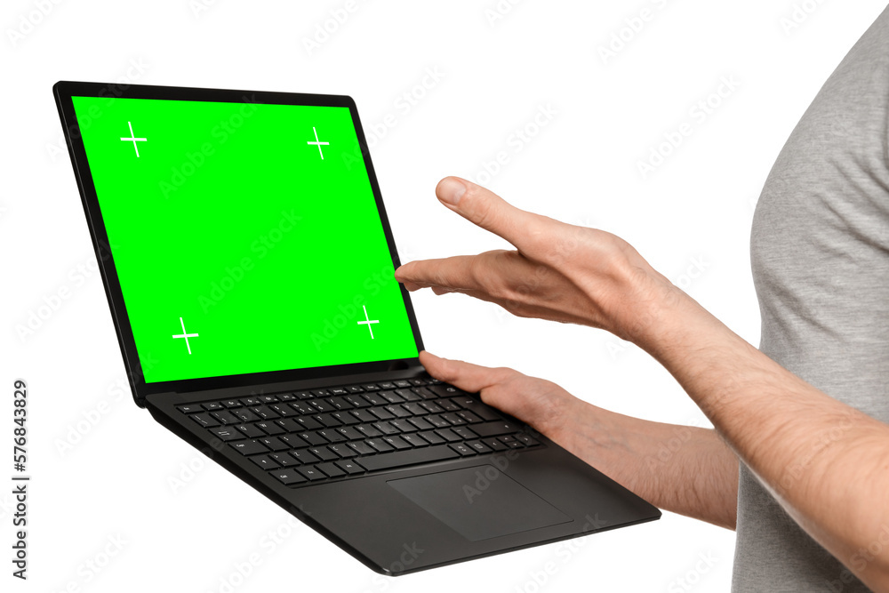A man in a T-shirt holds a laptop, an ultrabook and points to the screen with his hand. A man in a T-shirt holds a laptop, an ultrabook and points to the screen with his hand.