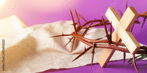 Fototapeta Crown of thorns, wooden cross and shroud on purple background, closeup