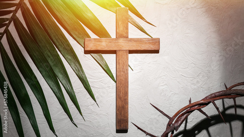 Fotografiet Crown of thorns with wooden cross and palm leaf on light background