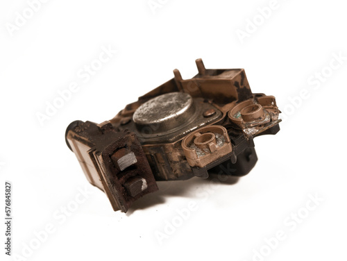 Heavily worn graphite brushes of an automobile alternator, isolated on a white background, close-up, selective focus.