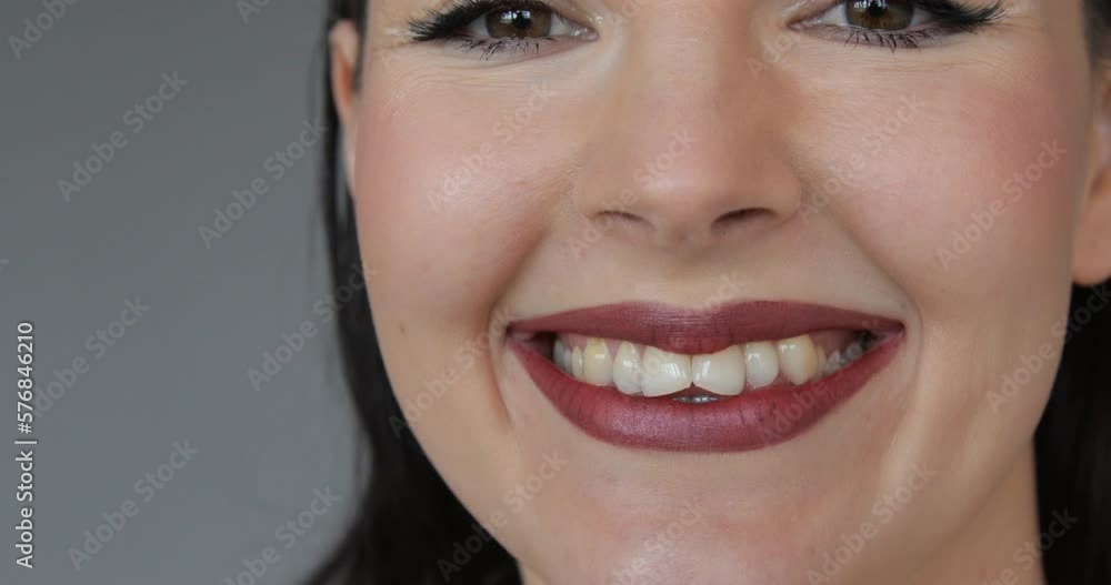Close-up of sweet kiss in camera. Charming woman with professional makeup and bright lipstick smiles and flirts. Close-up of sweet kiss in camera. Charming woman with professional makeup and bright lipstick smiles and flirts.