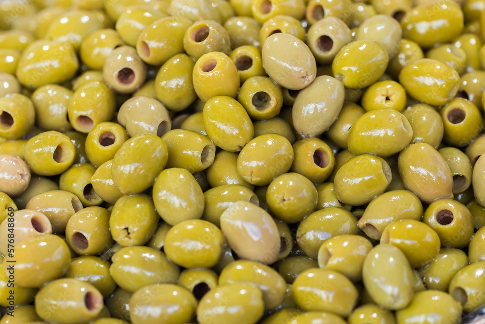 Green pitted olives closeup, background of green olives, street food market. Selective focus Green pitted olives closeup, background of green olives, street food market. Selective focus