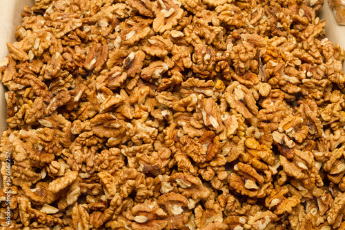 Background walnuts dry kernels. Close-up texture of heap of unshelled walnuts, overhead view. Healthy food.
