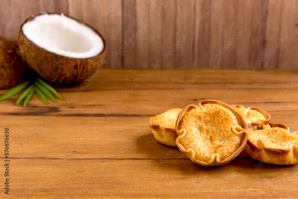 Fototapeta premium Coconut and coconut candy (cocadinha) on wooden background