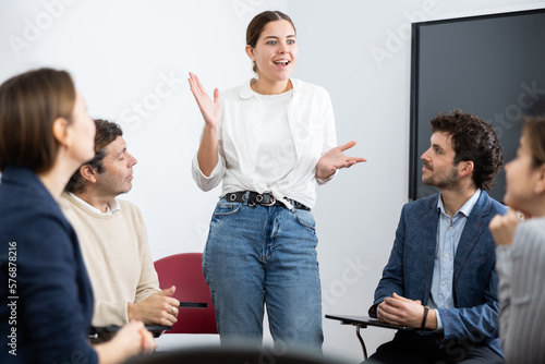 Konstfotografi Young female teacher giving lecture to group of student