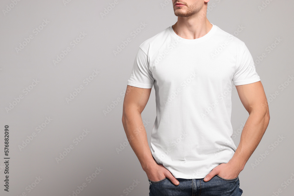 Man wearing white t-shirt on light grey background, closeup. Mockup for ...