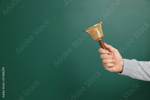 Teacher with school bell near chalkboard, closeup. Space for text photo