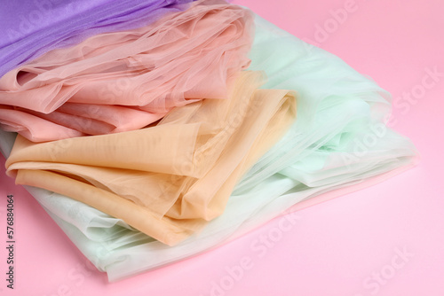 Beautiful colorful tulle fabrics on pink background