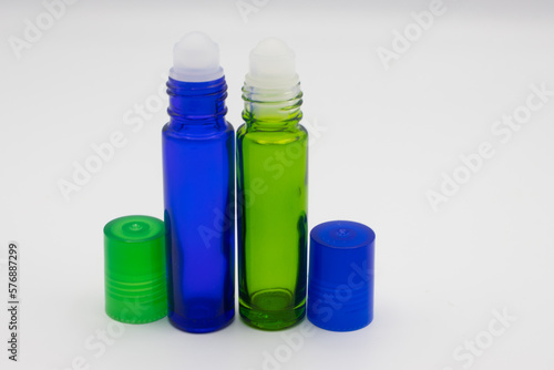 Empty blue and green glass roll on bottles