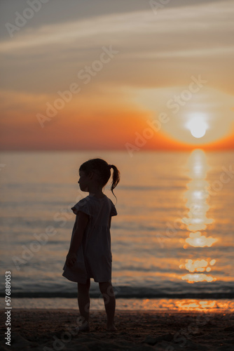 girl playing on the beach at sunset. Family holiday. High quality photo.