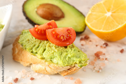 Delicious avocado toast with tomatoes on board, closeup