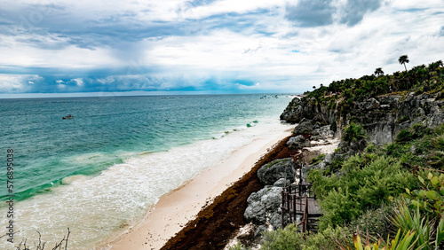 Vista desde el acantilado del mar caribe y la playa de Tulum con presencia de mucho sargazo en la arena