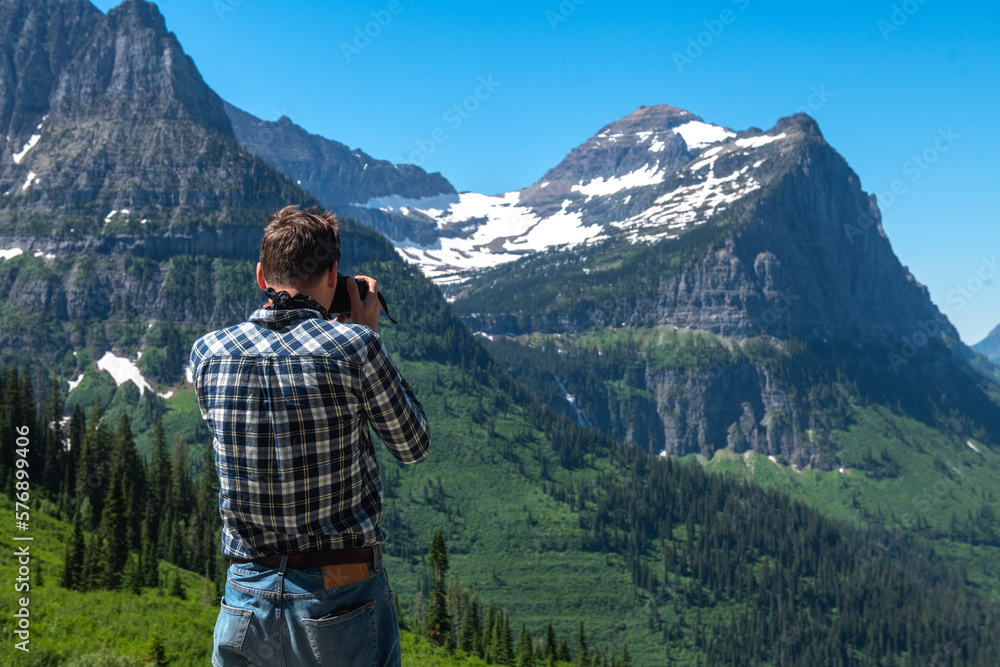 Tourist man taking pictures in Glacier National Park in Montana