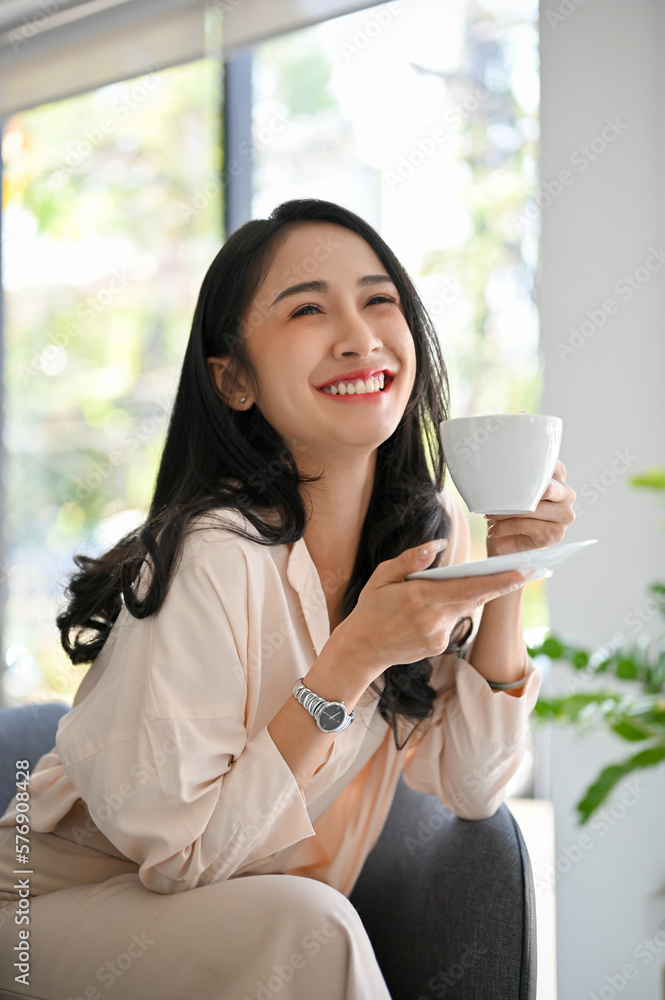 Attractive Asian businesswoman or female manager enjoys having coffee in her office. Attractive Asian businesswoman or female manager enjoys having coffee in her office.