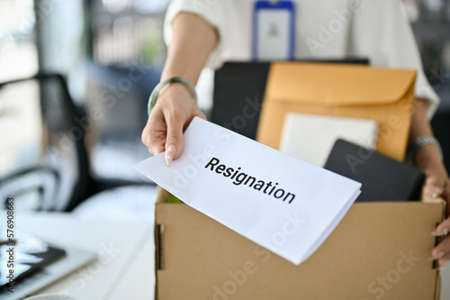 Fotografie Close-up image of a female office worker handing a resignation letter, quitting job by herself