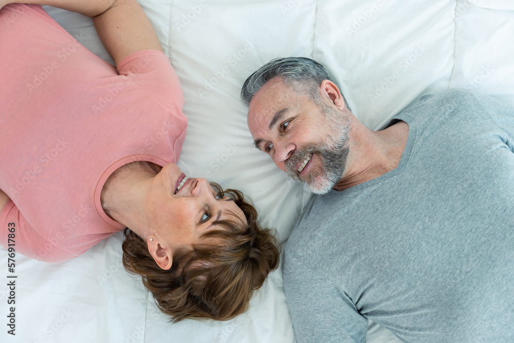 Caucasian senior older couple lying down on bed then look at each other. Caucasian senior older couple lying down on bed then look at each other.