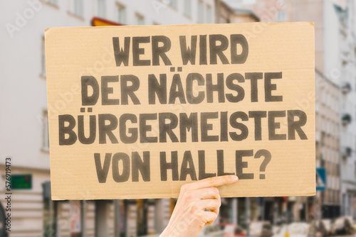 Wallpaper Mural The phrase " Who's the next mayor of Halle? " on a banner in men's hands blurred the background. Election. City management. Politics. Urban. Voter. Candidate Torontodigital.ca