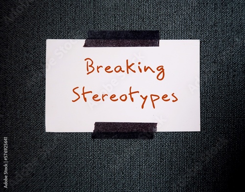 White card stick on office wall background with text message - BREAKING STEREOTYPES to stop generalization about how a group of people behaves, unfair and untrue belief about others photo