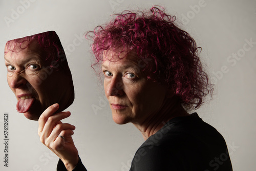 Wall Mural Composite photo of a middle aged caucasian woman with curly hair removing a mask