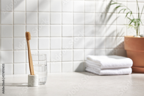 Various objects on a white tile background with warm sunlight shining through
