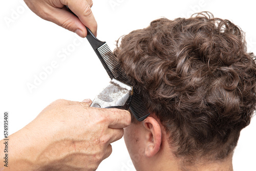 The hairdresser cuts a man's haircut with a clipper