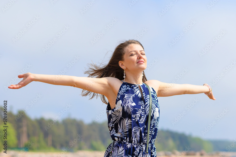 young beautiful woman, girl on beach breathing fresh air, turning her face to sun and wind. concept of freedom, vacation, travel young beautiful woman, girl on beach breathing fresh air, turning her face to sun and wind. concept of freedom, vacation, travel