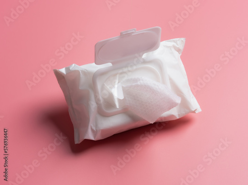 Open wet wipes flow pack on pink background,flat lay. Space for text