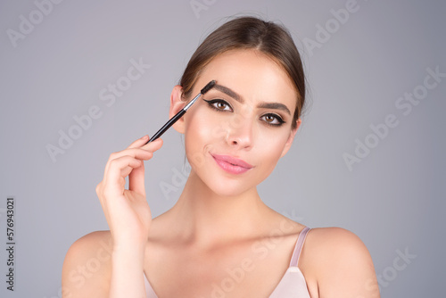 Eyebrow makeup. Beauty model shaping brows with brow pencil closeup. Womans eyebrows with eyebrow brush. Natural make up. Modeling brows. Comb eyebrows.