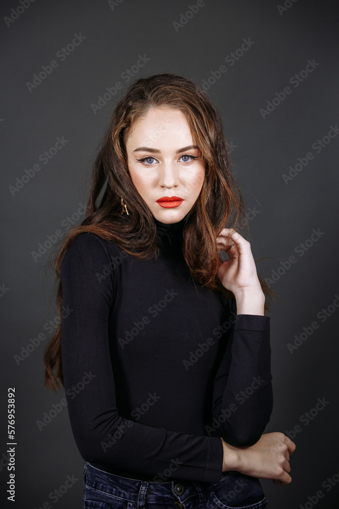 A model in dark clothes with bright make-up on a dark background A model in dark clothes with bright make-up on a dark background