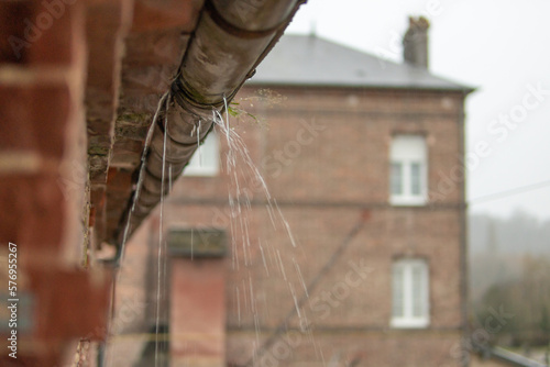 a gutter on a building, an old drainpipe close-up, water flows through rotten metal, there is a place for an inscription