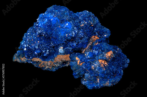 Azurite is a soft, deep blue copper mineral produced by weathering of copper ore deposits. Isolated in black background.