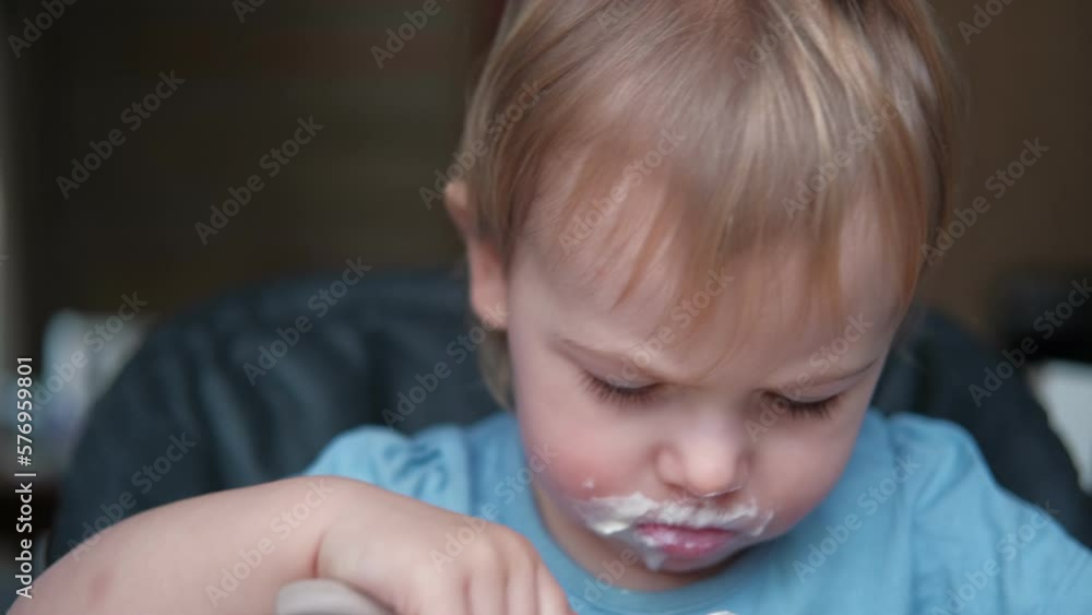 Toddler Sitting in Highchair Eating Greek Yogurt. Funny Cute Baby Eats in the Kitchen. Little Girl Learning to Eat. Child Feeding Himself by Silicone Spoon at Home. Breakfast with Dairy Products. 4K Toddler Sitting in Highchair Eating Greek Yogurt. Funny Cute Baby Eats in the Kitchen. Little Girl Learning to Eat. Child Feeding Himself by Silicone Spoon at Home. Breakfast with Dairy Products. 4K