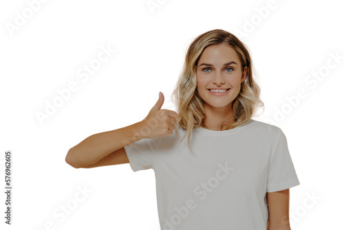 Happy young blonde female wearing white casual tshirt making thumbs up gesture and smiling cheerfully