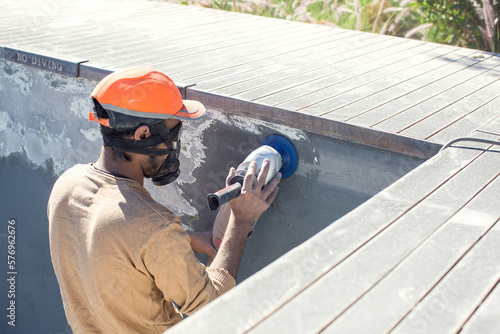Concrete ceiling surface of the pool grinding by angle grinder photo