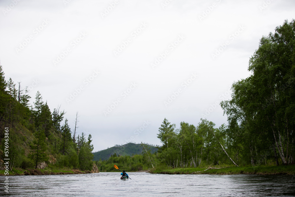 Woman paddles her kayak down the Onon river in northern Mongolia. Woman paddles her kayak down the Onon river in northern Mongolia.