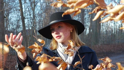 a young woman with red hair touching leaf