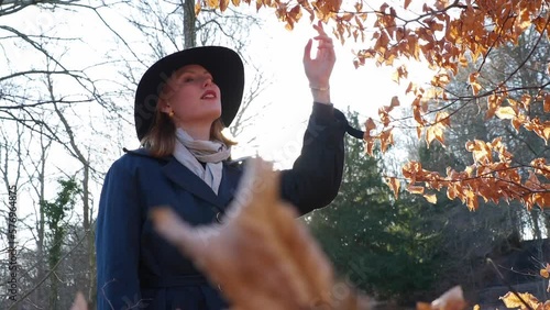 young woman in forest looking at tree