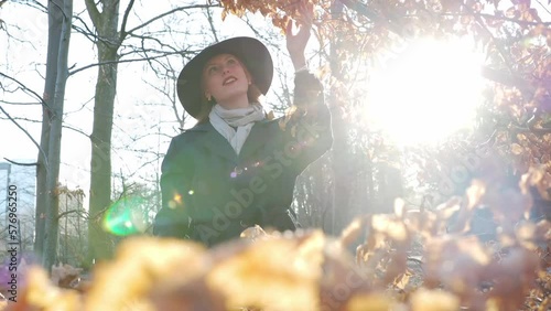 woman with hat looking at a tree in forest