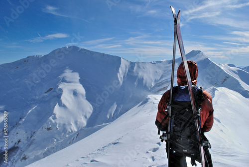 Male ski alpinist admiring mountain panorama. photo