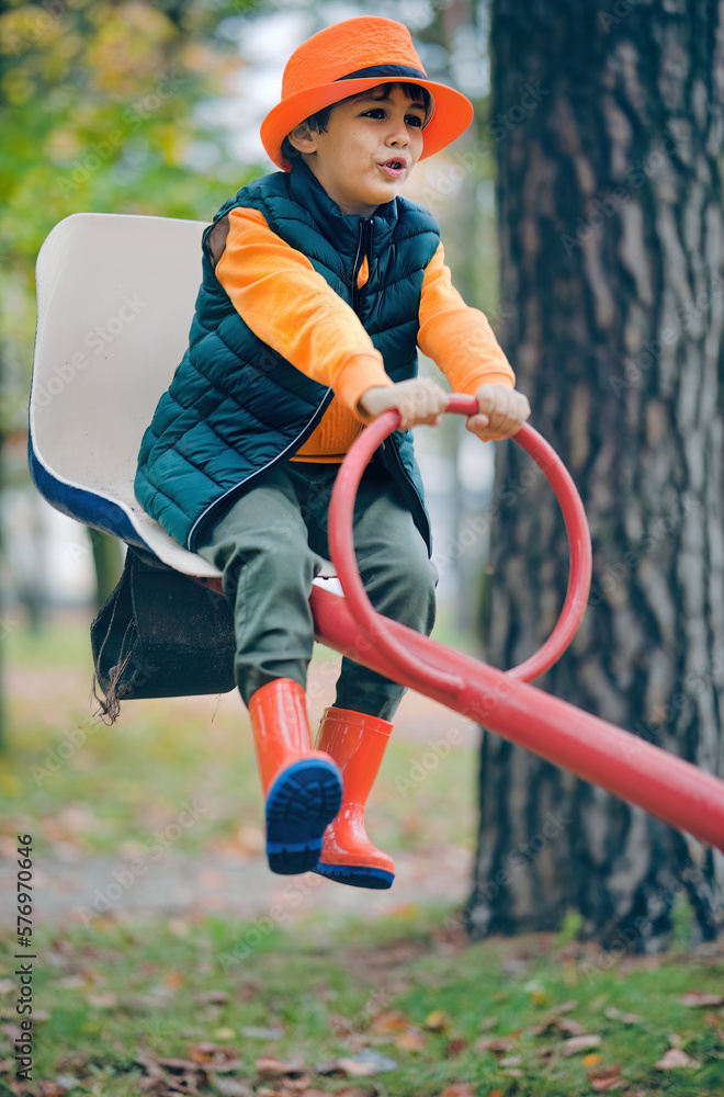 Obraz premium A little boy rides on a swing. Real emotions