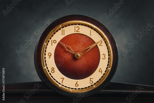 Close-up of vintage analog round table clock. Front view. Ten hours ten minutes.