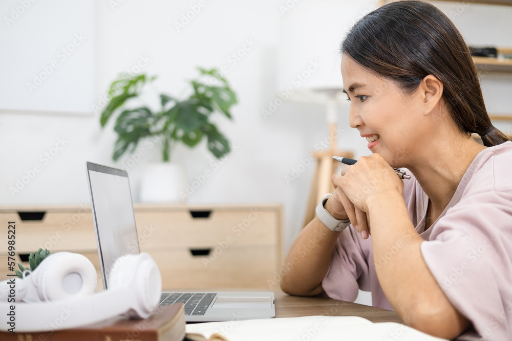 Happy asian woman in online learning , enjoying watching educational webinar on laptop. Smiling young businesswoman holding video call with clients partners.Young female student study in home. Happy asian woman in online learning , enjoying watching educational webinar on laptop. Smiling young businesswoman holding video call with clients partners.Young female student study in home.
