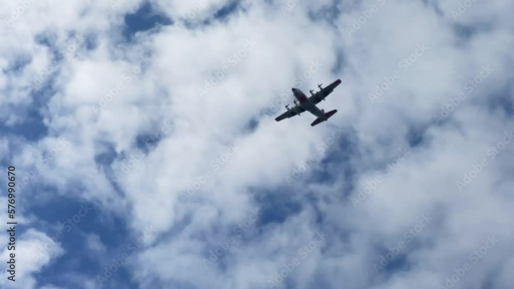 Propellers Military Plane Flying At Low Altitude in Sky At Cloudy Day, Low Angle View Propellers Military Plane Flying At Low Altitude in Sky At Cloudy Day, Low Angle View