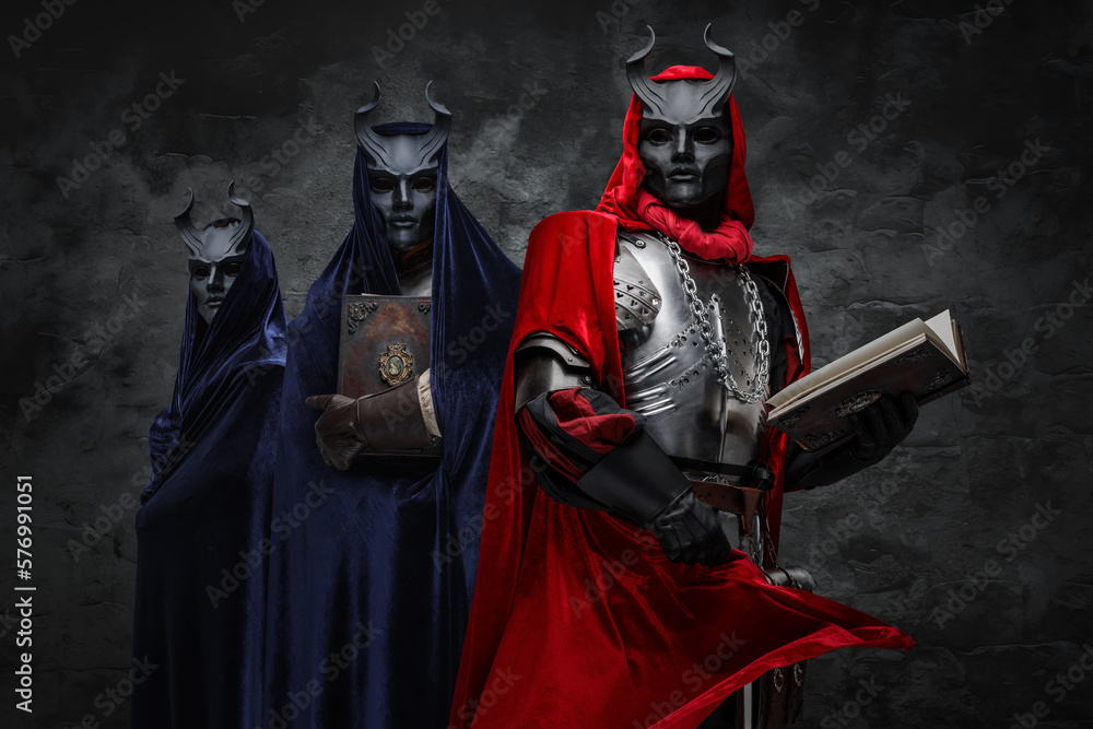 Naklejka premium Studio shot of mysterious brotherhood of cult dressed in mantles and horned masks.