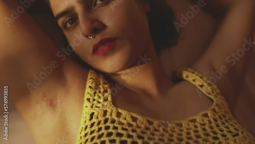Brunette girl with red lips and yellow outfit looking towards the camera. Blurred overhead shot from above. photo