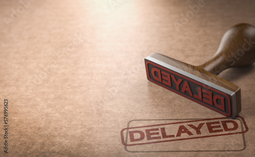 Фотография Rubber stamp over cardboard background with the word delayed stamped on it