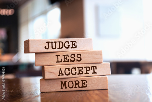 Wooden blocks with words 'JUDGE LESS ACCEPT MORE'. photo